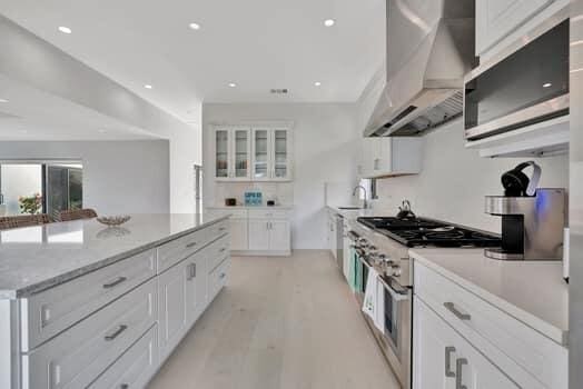 kitchen featuring white cabinets, wall chimney exhaust hood, and stainless steel appliances