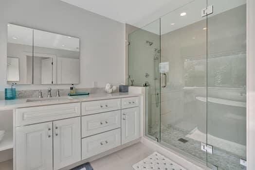 bathroom with tile patterned flooring, a shower with door, and vanity