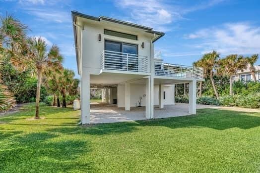 back of property with a yard and a patio