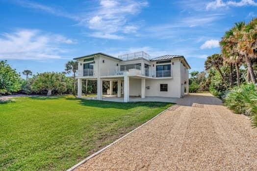 back of house with a yard, a patio area, and a balcony