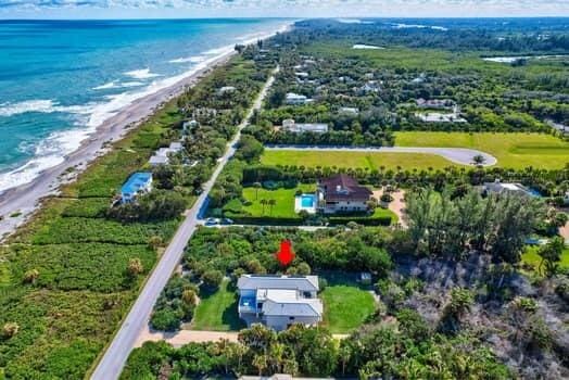 drone / aerial view featuring a beach view and a water view