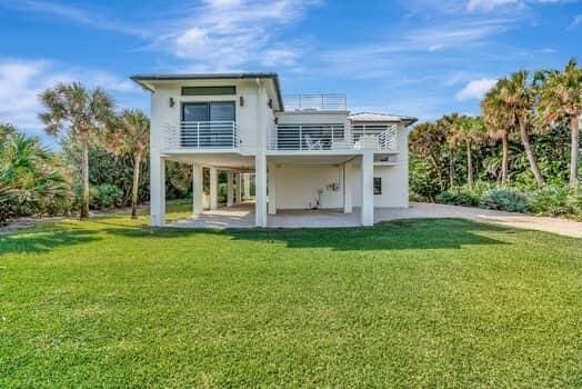 back of house with a yard and a patio