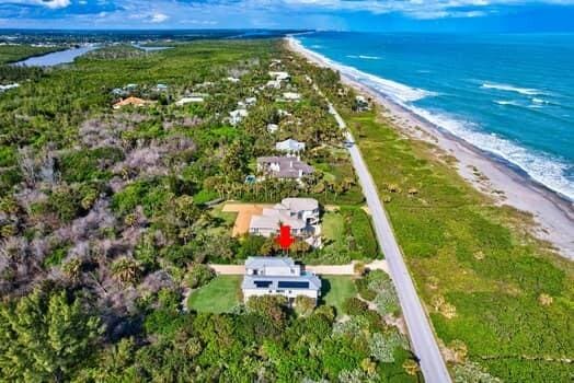 birds eye view of property with a water view and a view of the beach