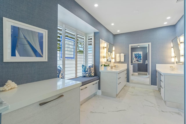 full bathroom with marble finish floor, recessed lighting, two vanities, a sink, and baseboards