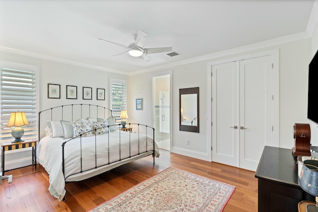 bedroom featuring visible vents, ornamental molding, a ceiling fan, light wood-type flooring, and baseboards