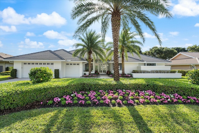 view of front of property with a garage, driveway, a tiled roof, and stucco siding