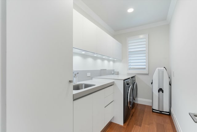 kitchen featuring light countertops, washing machine and dryer, white cabinetry, a sink, and modern cabinets