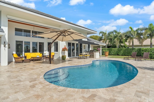 view of pool with an outdoor kitchen, outdoor lounge area, french doors, a fenced in pool, and a patio area