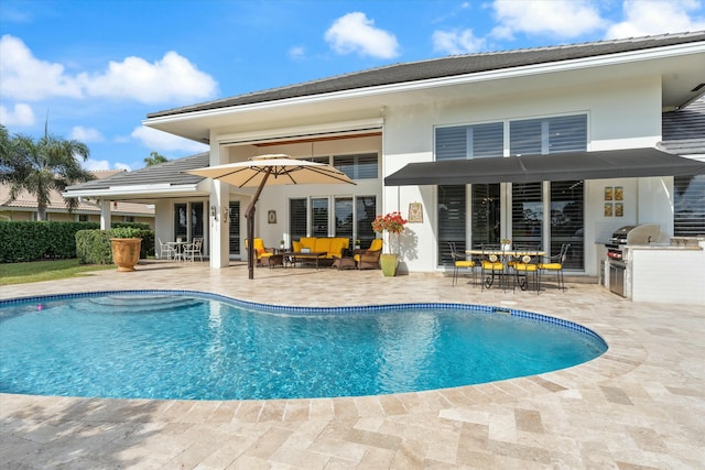 back of property with a fenced in pool, stucco siding, exterior kitchen, a patio area, and outdoor dining space