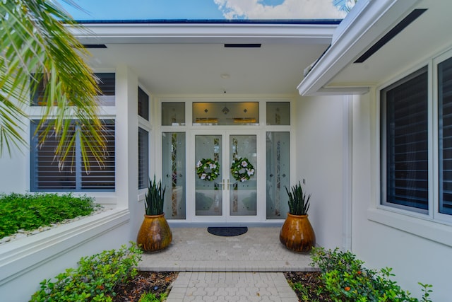 doorway to property featuring french doors and stucco siding