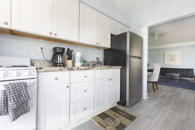 kitchen with white range oven, ceiling fan, light hardwood / wood-style flooring, white cabinets, and stainless steel refrigerator