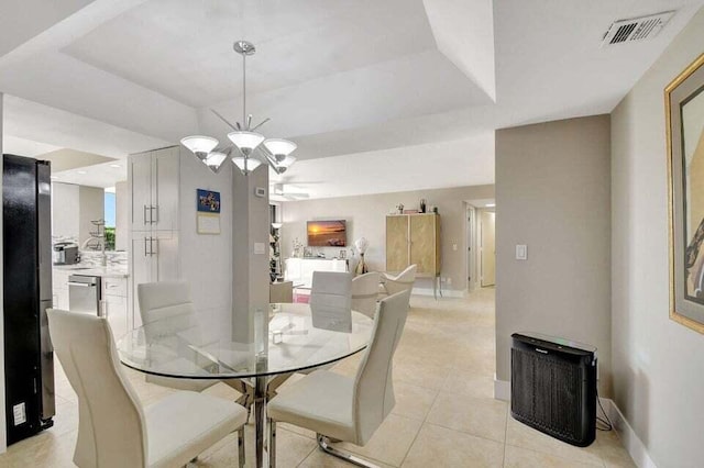 dining room featuring light tile patterned floors, a raised ceiling, and a notable chandelier