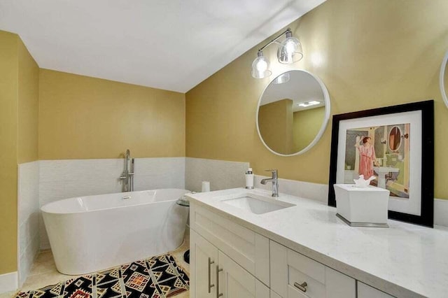 bathroom with tile patterned flooring, a bathtub, tile walls, and vanity