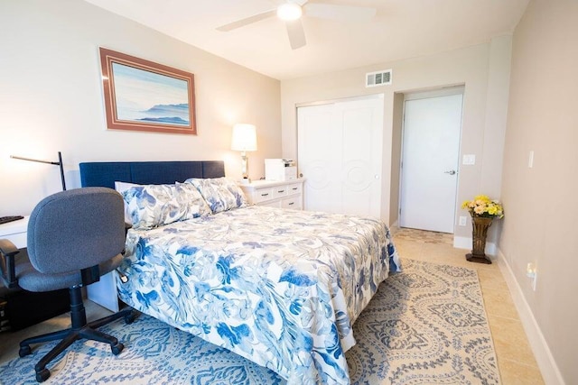 bedroom with ceiling fan, light tile patterned floors, and a closet