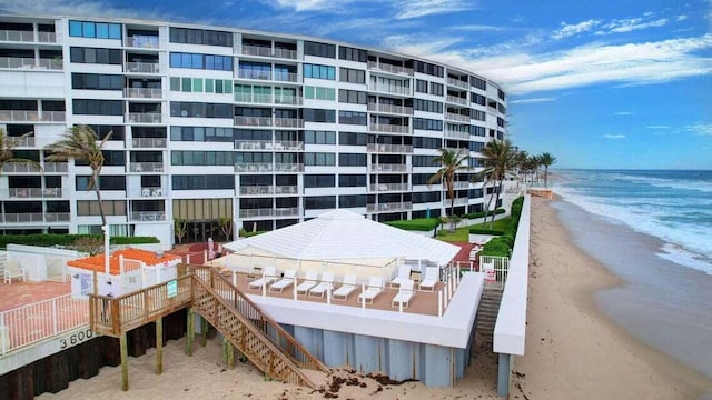 view of building exterior featuring a water view and a view of the beach