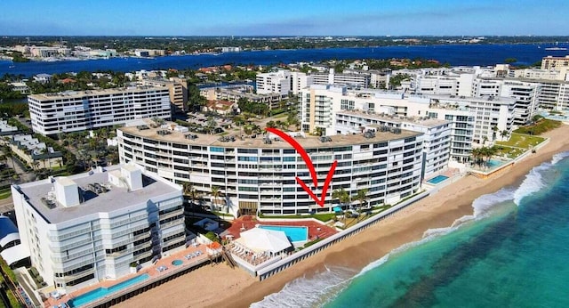 drone / aerial view with a water view and a beach view