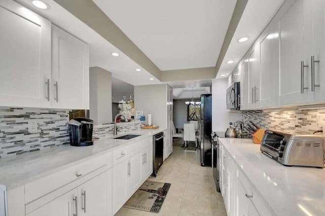 kitchen with white cabinetry, sink, stainless steel appliances, light stone counters, and light tile patterned flooring