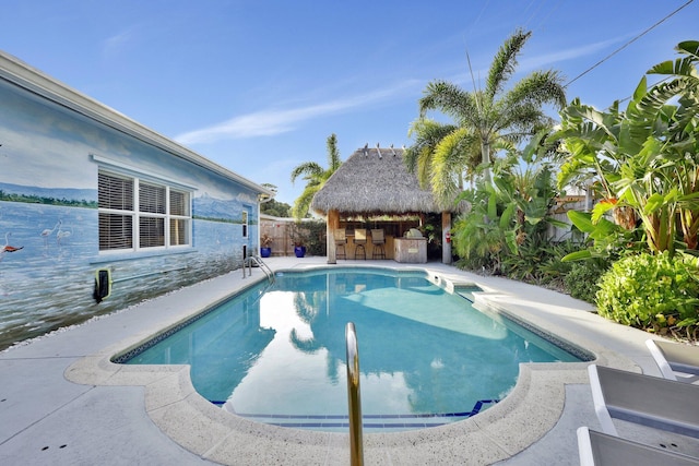 view of pool featuring a gazebo and exterior bar