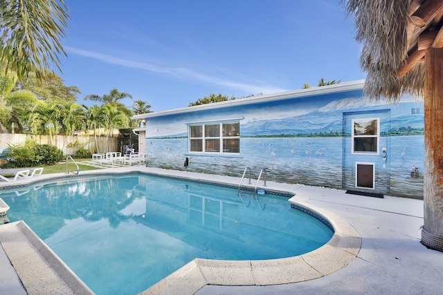 view of pool featuring a water view and a patio