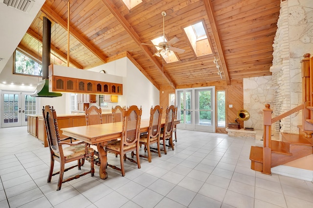 tiled dining room featuring high vaulted ceiling, french doors, a skylight, beamed ceiling, and wood ceiling