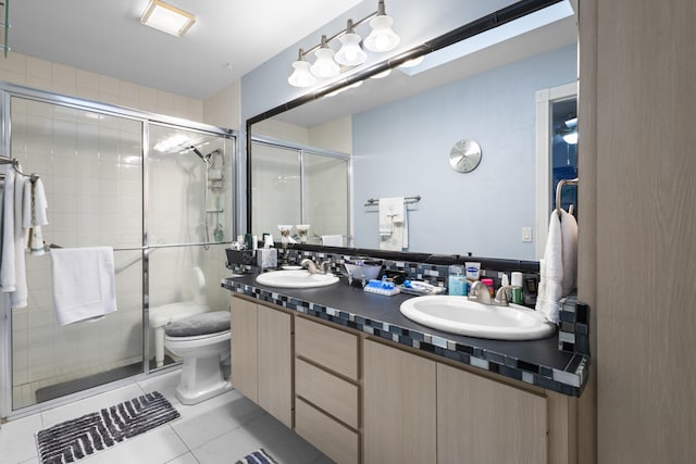 bathroom featuring vanity, a shower with door, tile patterned floors, toilet, and tasteful backsplash