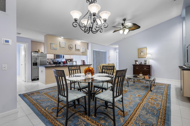 tiled dining room featuring ceiling fan with notable chandelier and vaulted ceiling