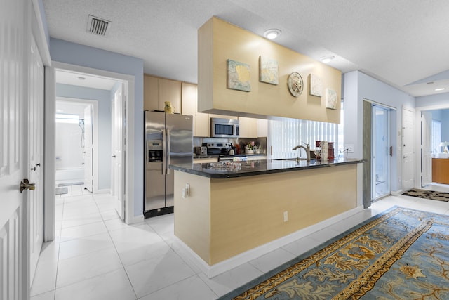 kitchen featuring kitchen peninsula, a textured ceiling, stainless steel appliances, sink, and light tile patterned flooring