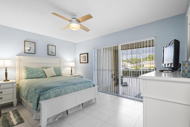 bedroom with access to exterior, ceiling fan, light tile patterned flooring, and a textured ceiling