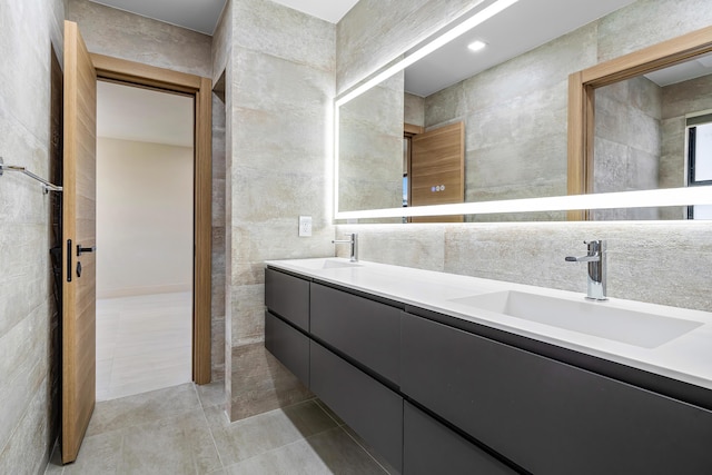 bathroom featuring vanity and tile walls