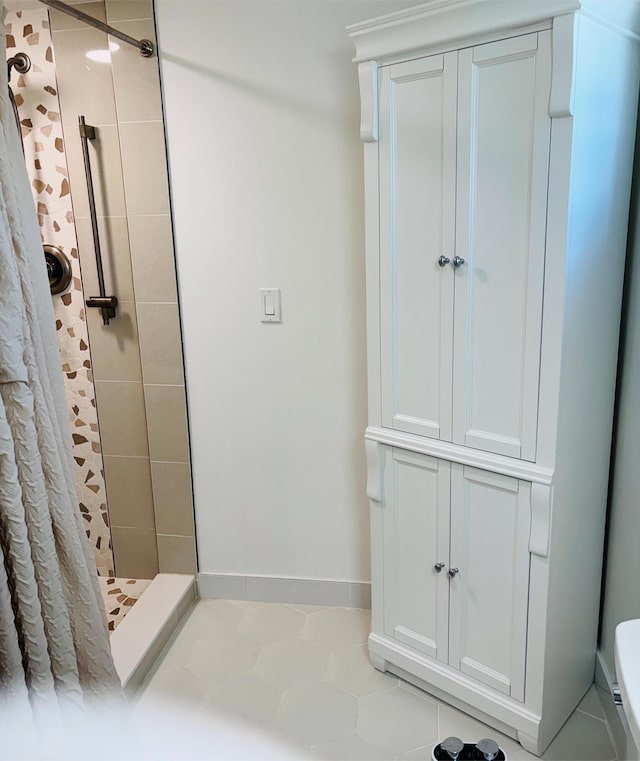 bathroom featuring toilet, a shower with curtain, and tile patterned floors