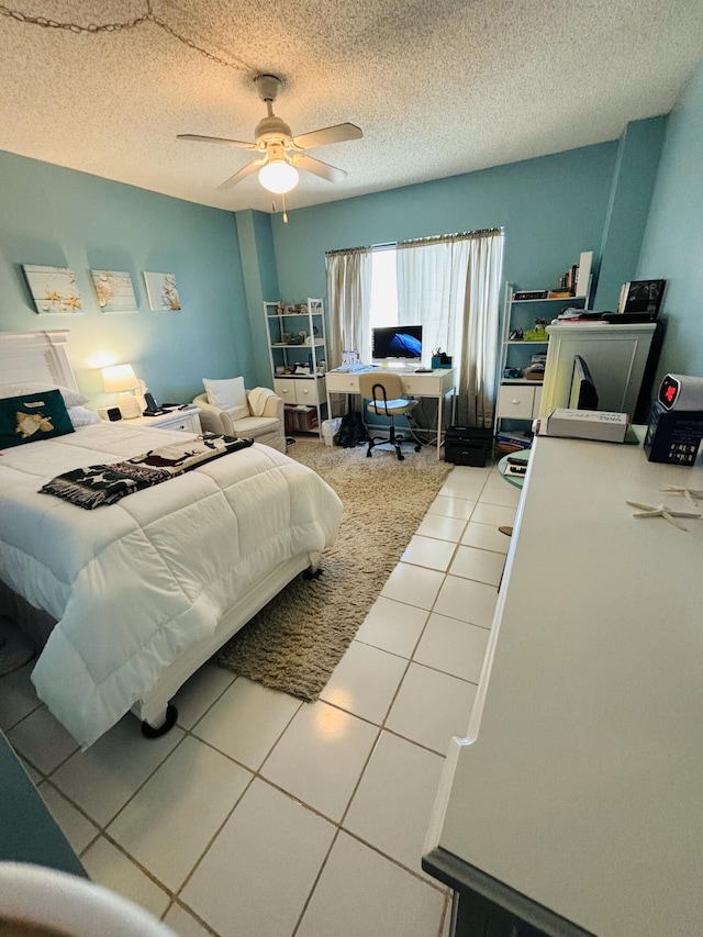 tiled bedroom featuring a textured ceiling and ceiling fan