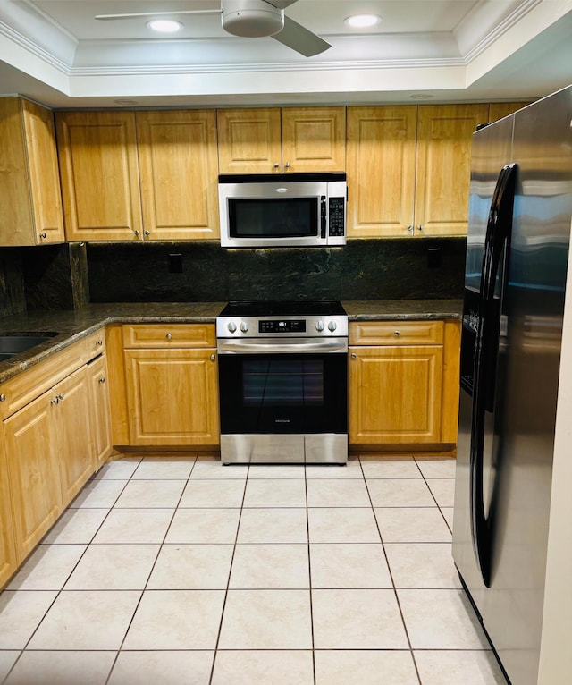 kitchen with a raised ceiling, decorative backsplash, ornamental molding, light tile patterned flooring, and stainless steel appliances