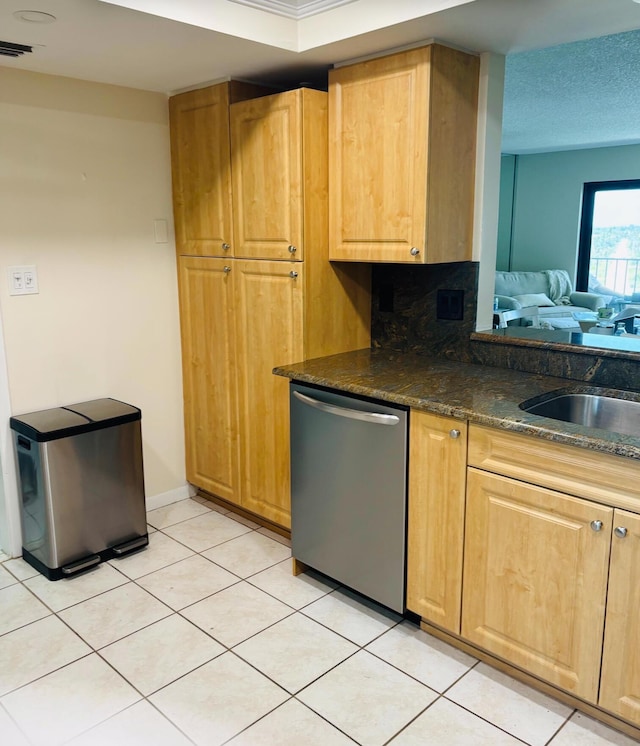 kitchen featuring tasteful backsplash, dishwasher, light tile patterned floors, and sink