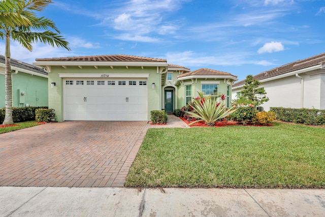 mediterranean / spanish house featuring a garage and a front lawn