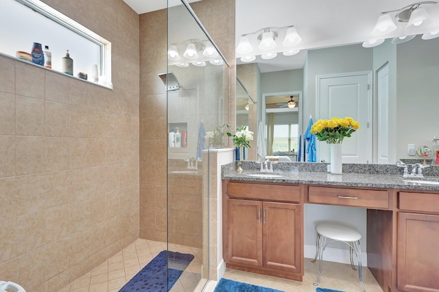 bathroom with tile patterned floors, ceiling fan, vanity, and tiled shower