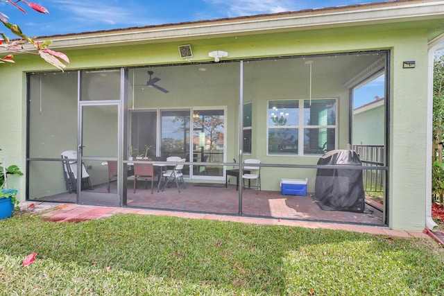 rear view of property with a sunroom and a yard