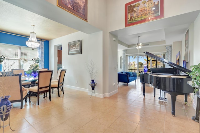 tiled dining room with a textured ceiling and ceiling fan with notable chandelier