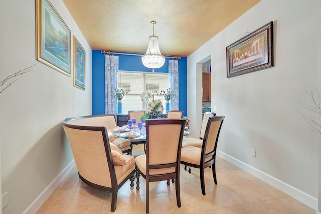 tiled dining room with a chandelier and a textured ceiling