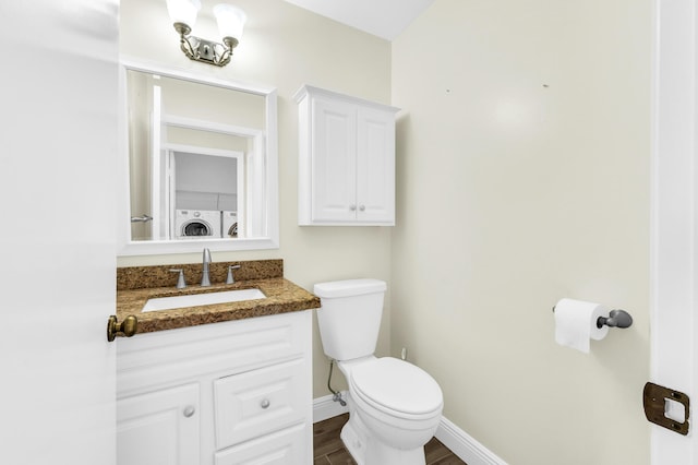 bathroom featuring hardwood / wood-style floors, vanity, toilet, and independent washer and dryer