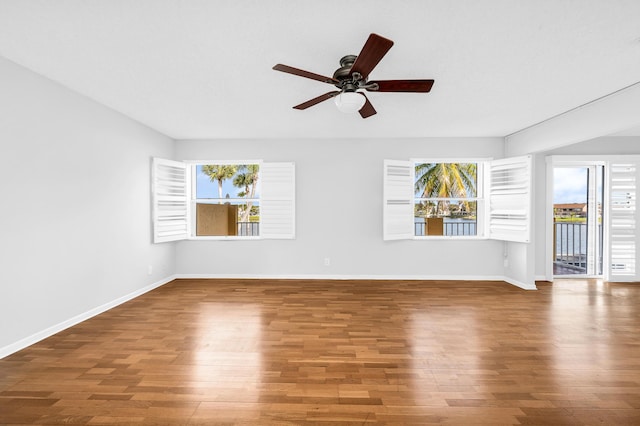 empty room featuring hardwood / wood-style flooring, ceiling fan, and a healthy amount of sunlight