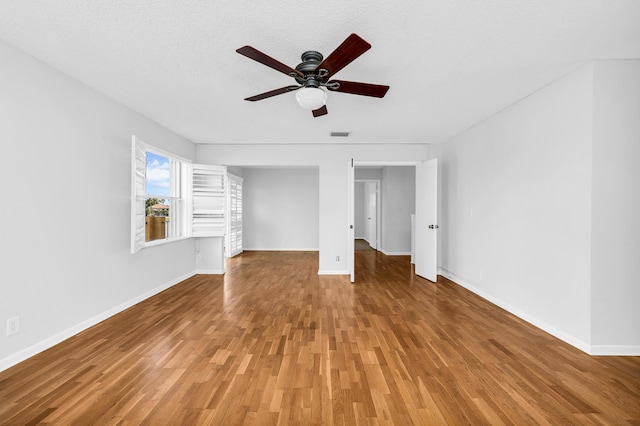 unfurnished bedroom featuring wood-type flooring, a textured ceiling, and ceiling fan