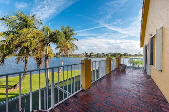 exterior space featuring a balcony and a water view