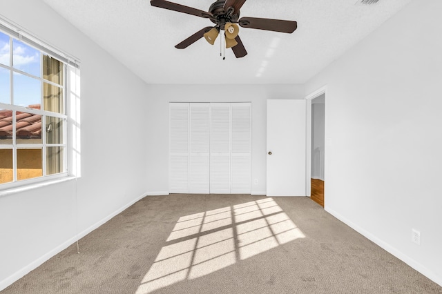 unfurnished bedroom with ceiling fan, light colored carpet, and a closet