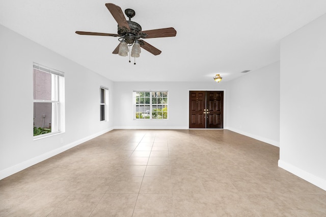 tiled spare room with ceiling fan