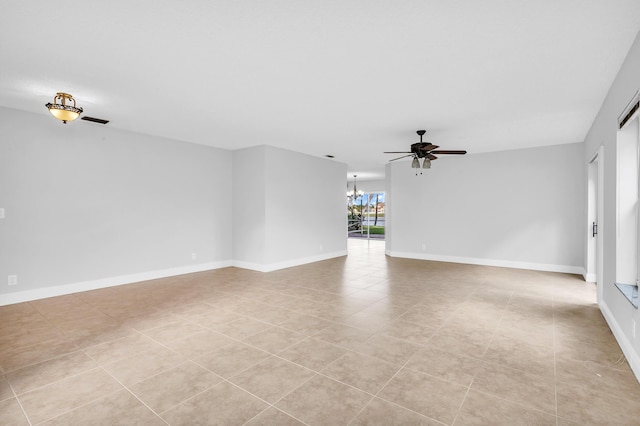 unfurnished room with ceiling fan with notable chandelier and light tile patterned floors