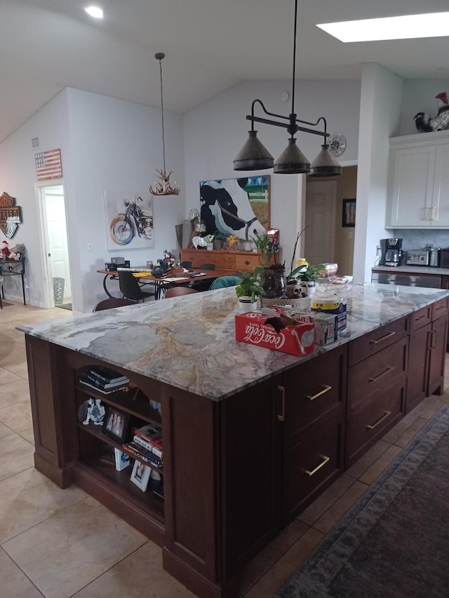 kitchen with white cabinetry, a center island, hanging light fixtures, lofted ceiling, and dark brown cabinets