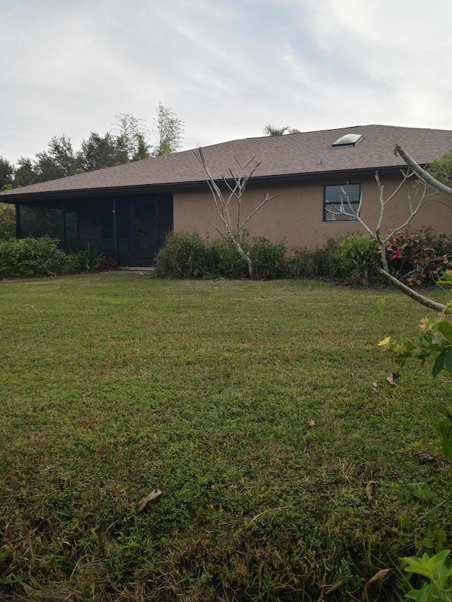 view of side of home with a yard and a sunroom