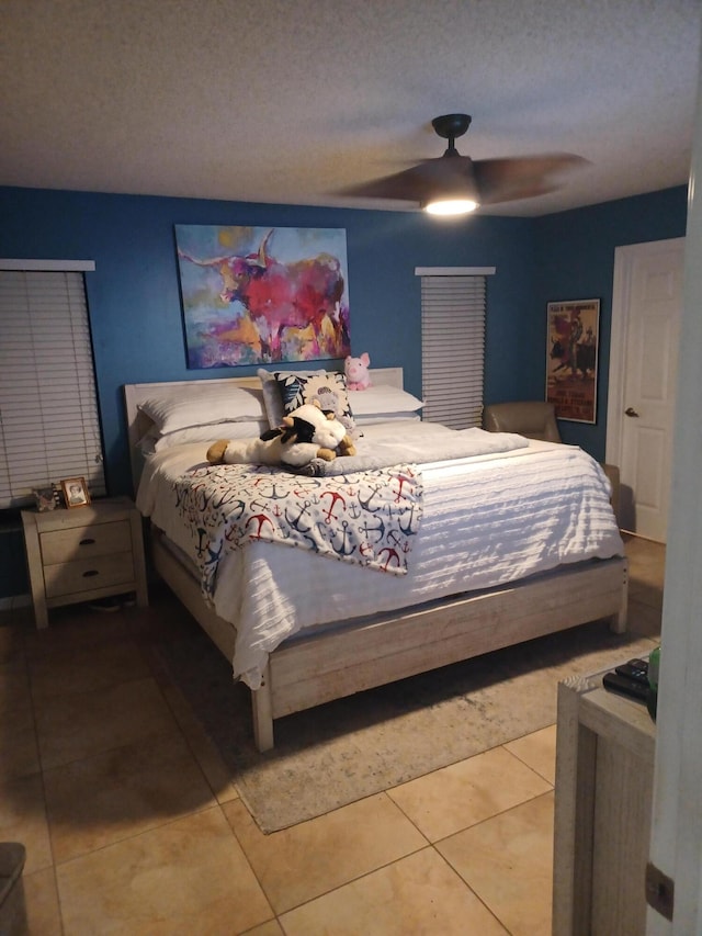 bedroom featuring tile patterned flooring, a textured ceiling, and ceiling fan