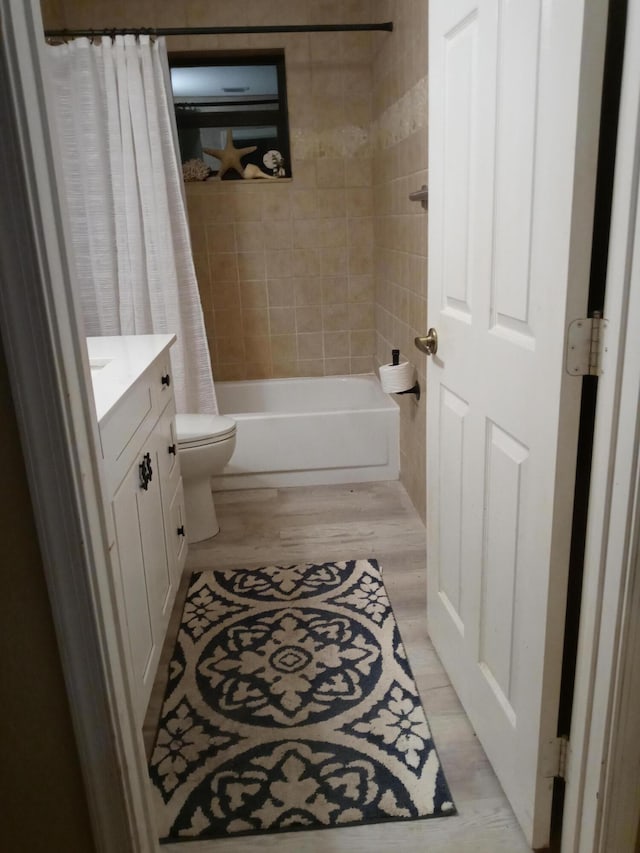 full bathroom with hardwood / wood-style floors, vanity, toilet, and shower / bath combination with curtain