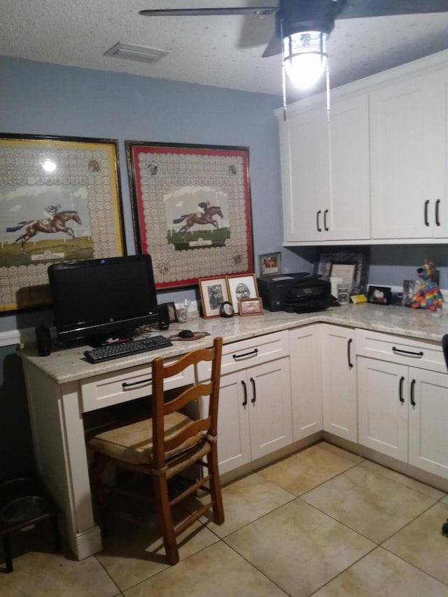 kitchen with light tile patterned floors, a textured ceiling, white cabinetry, and ceiling fan